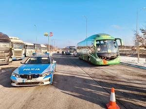 widok na autobus i radiowóz na parkingu.