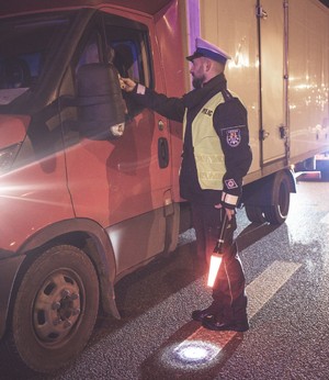 Kierowca badany alkomatem przez policjanta.