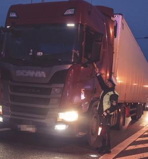 Kierowca badany alkomatem przez policjanta.