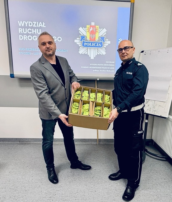 Dyrektor Wojewódzkiego Ośrodka Ruchu Drogowego w Łodzi, Michał Gogolewski, przekazuje na ręce Naczelnika Wydziału Ruchu Drogowego Komendy Wojewódzkiej Policji w Łodzi podinspektora Jarosława Złotkowskiego 8 tysięcy elementów odblaskowych.