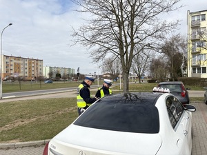Policjant kontroluje kierowce taksówki.