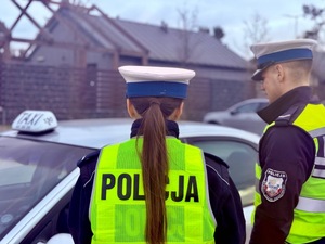 Policjant kontroluje kierowce taksówki.