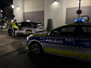 Policjanci kontrolują kierowcę taksi.