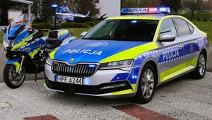 Radiowóz, motocykl policyjny, w tle policyjny helikopter.