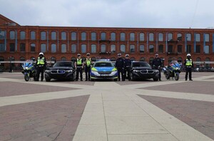 Zdjęcie przedstawia funkcjonariuszy, samochody i motocykle grupy.