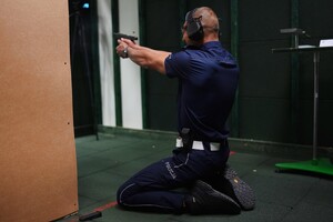 Policjant strzela na strzelnicy.