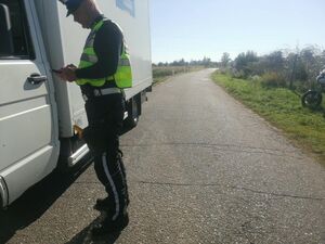 Policjant kontrolujący samochód.