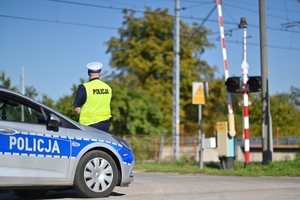 Policjant obserwujący przejazd kolejowy.