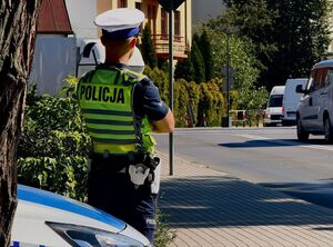 Policjant obserwujący przejazd kolejowy.