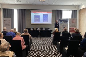 Policjant omawia aplikację mobilną &quot;Moja Komenda&quot;. Na zdjęciu uczestnicy seminarium zorganizowanego przez Narodowy Instytut Samorządu Terytorialnego - państwową jednostkę budżetową podległą Ministrowi Spraw Wewnętrznych i Administracji.