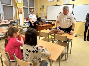 Funkcjonariusze Straży Miejskiej w Łodzi opowiadają dzieciom w jaki sposób należy udzielać pierwszej pomocy zwierzętom.