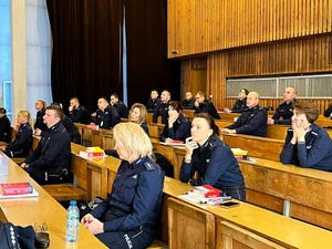 Policjanci w mundurach, rozwiązujący na auli test wiedzy w ramach konkursu.