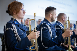 Policjanci w mundurach trzymają w reku instrumenty muzyczne.