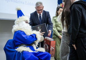 Niebieski mikołaj rozdaje prezenty.