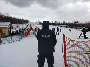 Policjant w mundurze obserwuje stok.