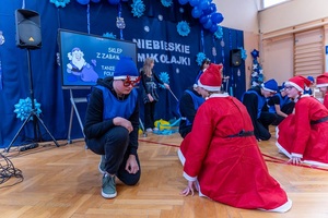 Policjanci wraz z dziećmi podczas świątecznego wydarzenia pod nazwą Niebieskie Mikołajki.