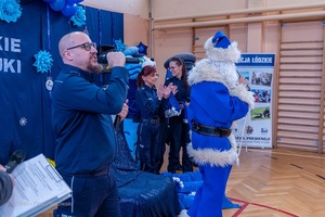 Policjanci wraz z dziećmi podczas świątecznego wydarzenia pod nazwą Niebieskie Mikołajki.