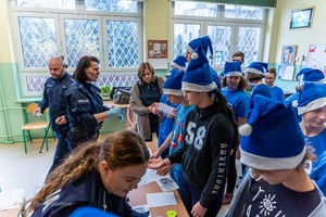 Policjanci wraz z dziećmi podczas świątecznego wydarzenia pod nazwą Niebieskie Mikołajki.