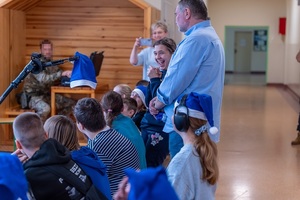 Policjanci wraz z dziećmi podczas świątecznego wydarzenia pod nazwą Niebieskie Mikołajki.