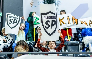 Zmagania sportowe dzieci na sali gimnastycznej w obecności policjantów  i aktorów.