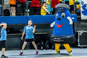 Zmagania sportowe dzieci na sali gimnastycznej w obecności policjantów  i aktorów.