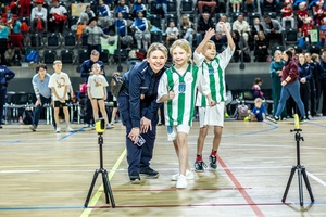 Zmagania sportowe dzieci na sali gimnastycznej w obecności policjantów  i aktorów.