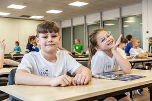 Zmagania sportowe dzieci na sali gimnastycznej w obecności policjantów  i aktorów.