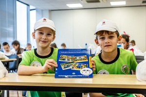 Zmagania sportowe dzieci na sali gimnastycznej w obecności policjantów  i aktorów.