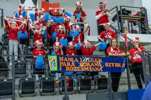 Zmagania sportowe dzieci na sali gimnastycznej w obecności policjantów  i aktorów.