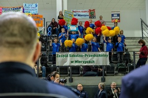 Zmagania sportowe dzieci na sali gimnastycznej w obecności policjantów  i aktorów.