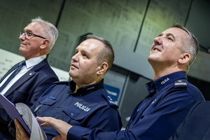 Zmagania dzieci podczas zawodów sportowych na sali gimnastycznej w obecności policjantów i aktorów.