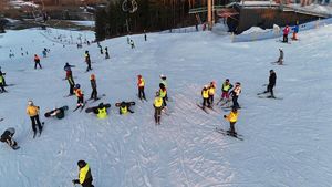 Dzieci ubrane w kamizelki odblaskowe zjeżdżają ze stoku na nartach.
