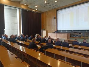 Umundurowani policjanci siedzą na auli.