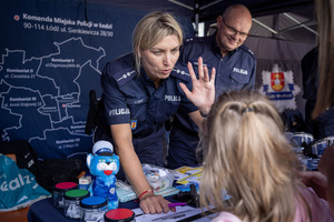 Policjantka przybija piątkę z dzieckiem.