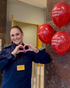 Policjantka pokazuje symbol serca, obok balony.
