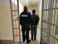 policjant prowadzi zatrzymanego