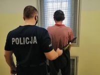 policjant prowadzi zatrzymanego