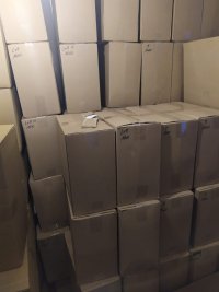 duża ilość opakowań tekturowych ustawionych pod ścianą pomieszczenia