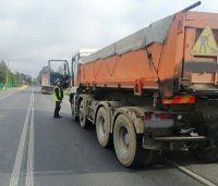 na zdjęciu widać tył dwóch samochodów ciężarowych kontrolowanych przez policjantów ruchu drogowego podczas akcji ,,TIR&quot;