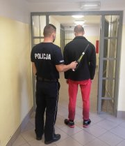 policjant prowadzi zatrzymanego