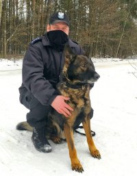 na zdjęciu przewodnik ze swoim psem służbowym na śniegu
