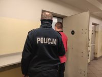 policjant z zatrzymanym przy policyjnej celi