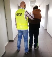 policjant prowadzi zatrzymanego