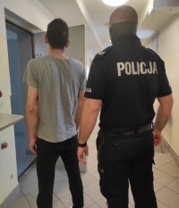 policjant z zatrzymanym przy policyjnej celi