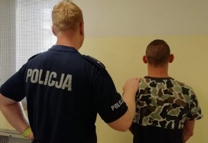 policjant prowadzi zatrzymanego