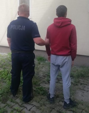 policjant prowadzi zatrzymanego