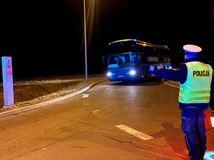 policjant kierujący ruchem w kierunku granicy, wskazuje drogę kierowcy autokaru