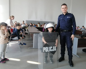 policjant z grupą przedszkolaków podczas wizyty dzieci w Komendzie Miejskiej Policji w Piotrkowie Trybunalskim