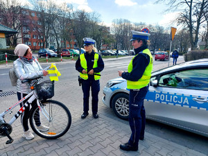 Policjantki przekazują rowerzystce elementy odblaskowe