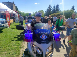 chłopiec w policyjnej czapce siedzi na policyjnym motorze